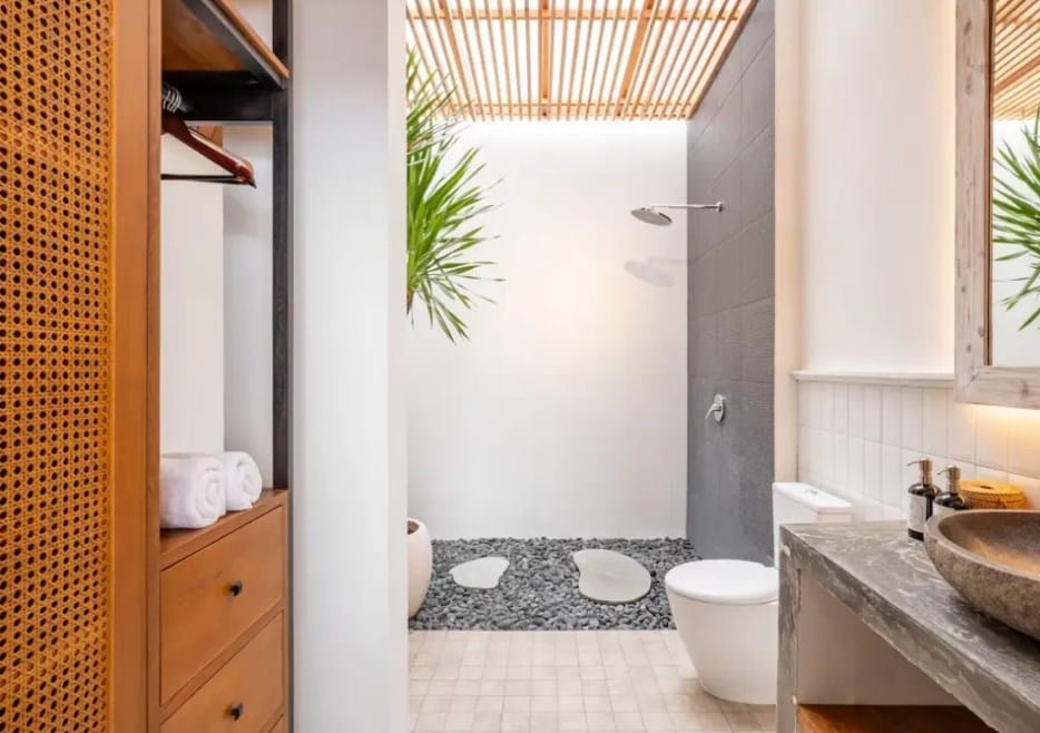 This image shows a Bali villa bathroom that has a reclaimed teak wood storage cabinet solution.