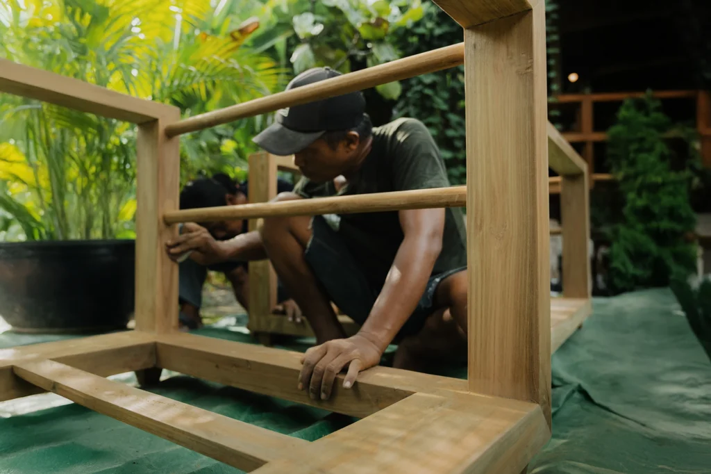Local artisan hand-finishing reclaimed teak at Nusantara Lifestyle workshop