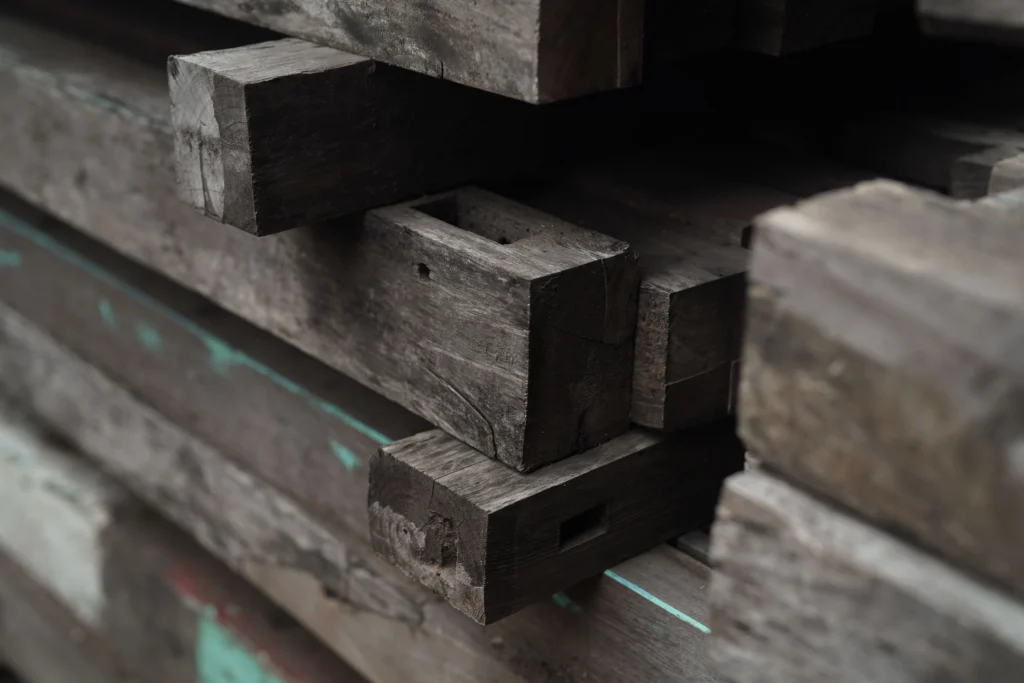 Reclaimed teak plank in the Nusantara Lifestyle workshop showing marks and natural weathering from decades of use