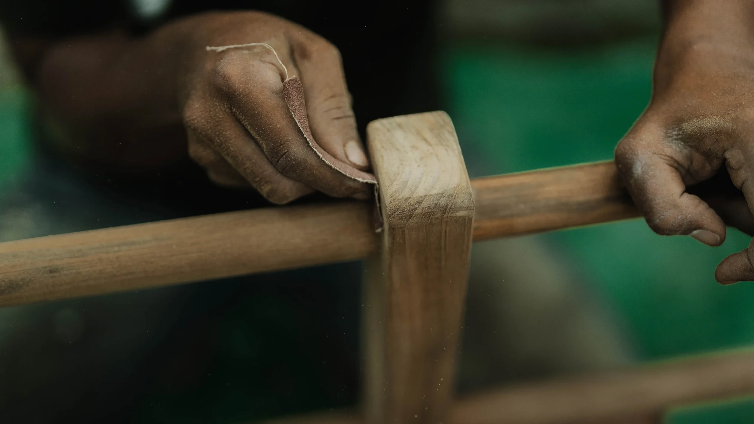 A skilled craftsperson sanding reclaimed teak in the Nusantara Lifestyle workshop