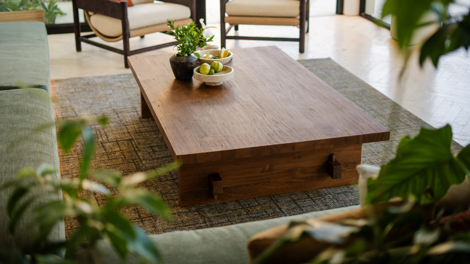 A custom reclaimed teak coffee table brings a warm, refined, and timeless character to a bright living room space.