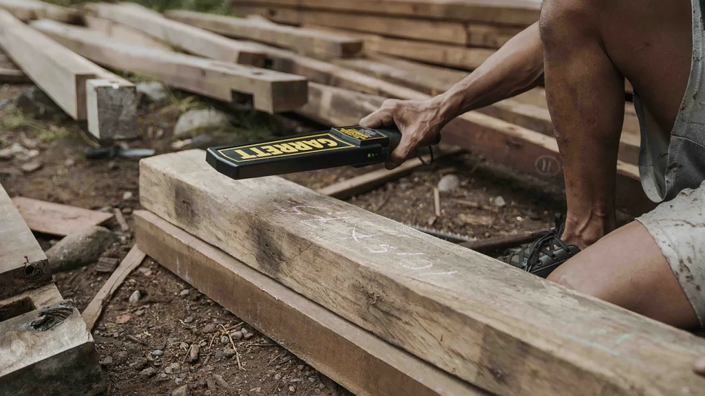 Craftspeople selecting reclaimed teak timber in an Indonesian workshop