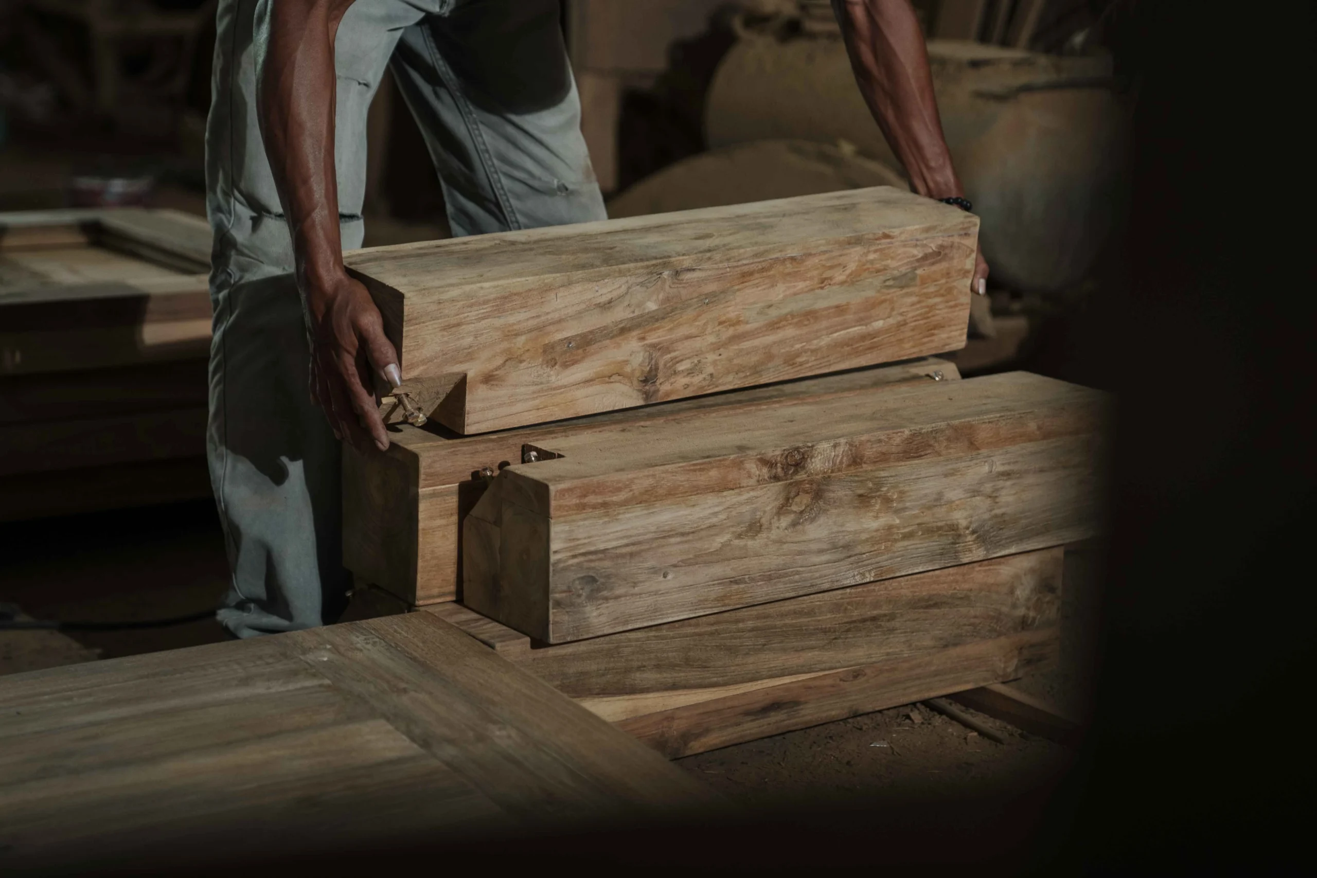 Craftsman inspecting reclaimed teak for character, cracks and structural condition
